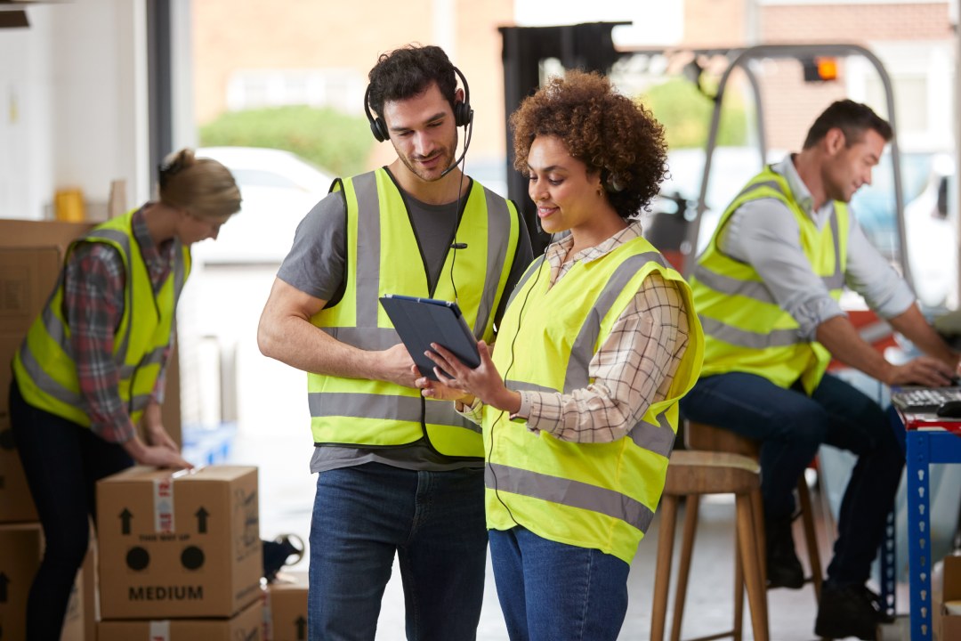 Trabajadores y trabajadoras con auriculares en logística  