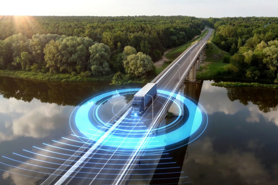 Autonomous semi-truck with a trailer, controlled by artificial intelligence, drives over a bridge over the river. Cargo delivery, transportation of the future. Artificial intelligence. Self driving.
