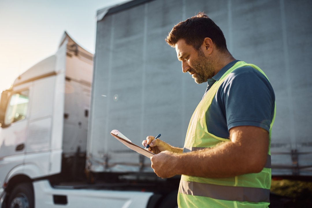 Mid adult truck dispatcher checking shipment list