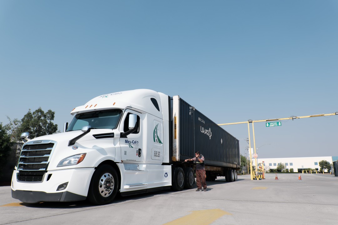 White logistics truck in parking lot.