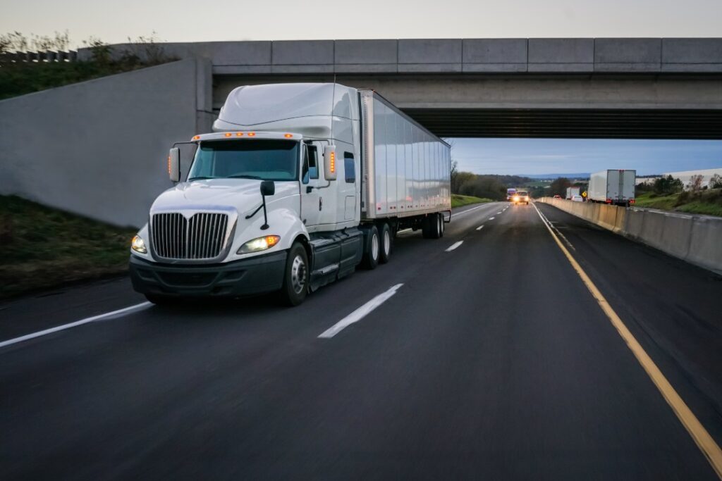 Semi-truck commercial vehicle 18 wheeler on highway with overpass