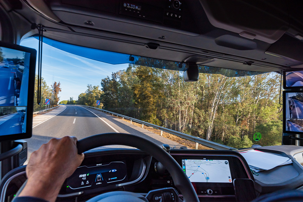 A driver in a truck with a camera on the dashboard, highlighting transport logistics for US-Mexico trade.