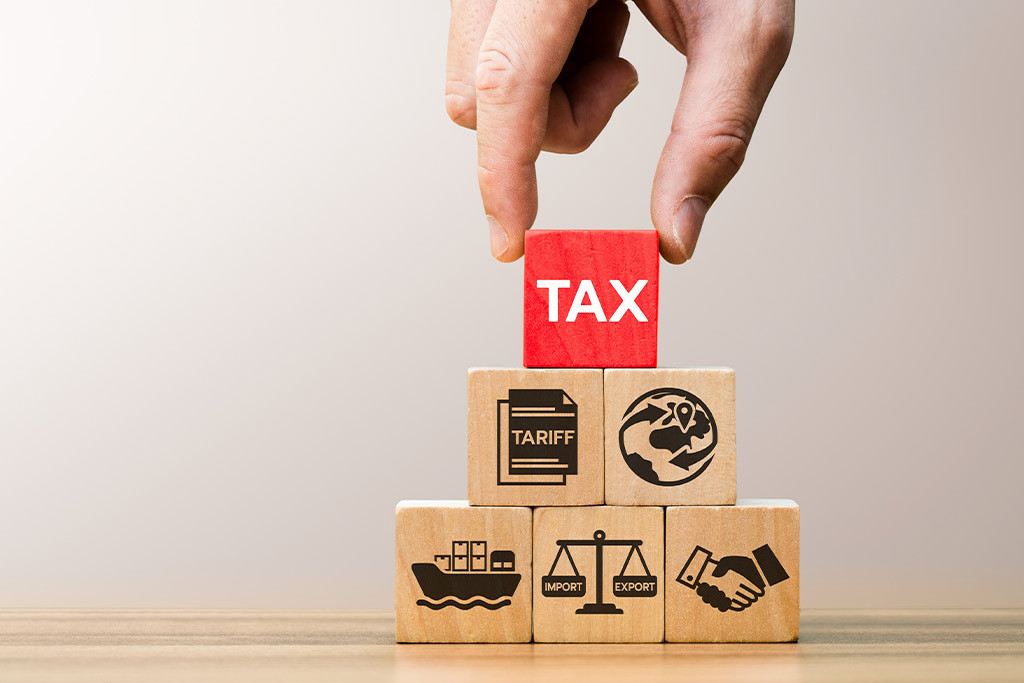 Tax concept illustrated with wooden blocks and icons, highlighting equipment relocations from Tijuana to US manufacturing hubs.